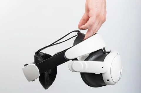 Innovative virtual reality headset being held by hand in modern, minimalist.. Stock Photos