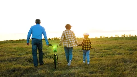 Inquisitive kid explores hidden trails of countryside with parents on sunny day Stock Footage 257962367