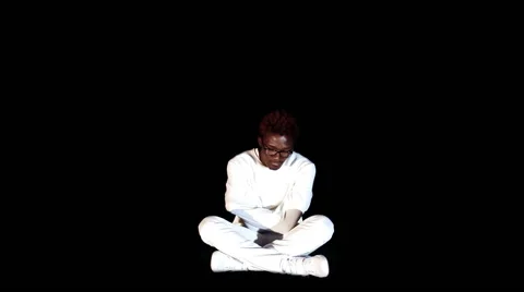 An insane black man in his forties wearing a straitjacket sitting in a dark of Stock Footage 59088891