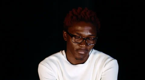 An insane black man in his forties wearing a straitjacket sitting in a dark of Video stock 59088923