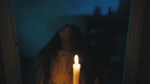 Insane witch holding burning candles and tilting head back unnaturally, magic Stock Footage 257005703