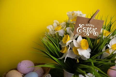 Inscription card with Happy Easter message on daffodil flowers and colorful e Stock Photos