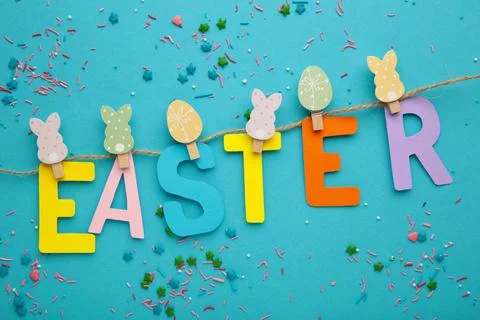 Inscription Easter on blue background, a rope with clothespins. The concept o Stock Photos