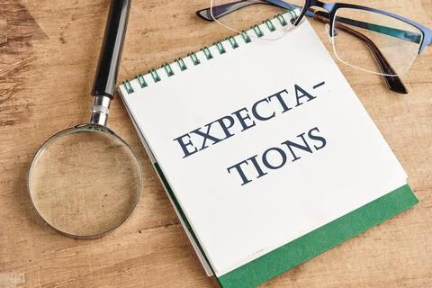 Inscription Expectations word on a notebook in a composition with a magnifyin Stock Photos