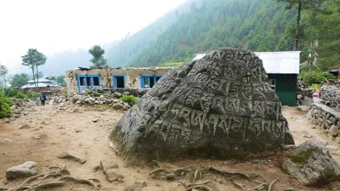 Inscriptions on a stone with mountains in the background Stock Footage 77446137