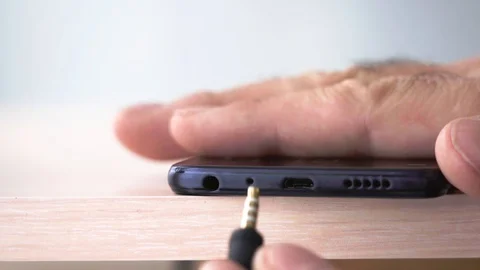 Insert and pull out the plug of the audio jack smartphone.  Stock Footage 129559014