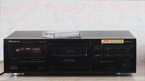 Insert an audio cassette into the music console deck Stock Footage 88949077