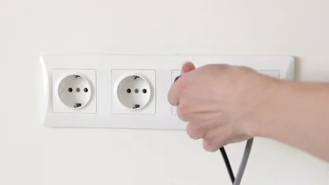 Insert electric plugs in the white wall socket Stock Footage 128229340