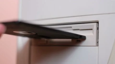 Insert a floppy disk into a vintage PC. Drive to read information packs to work Vídeos de archivo 195165406