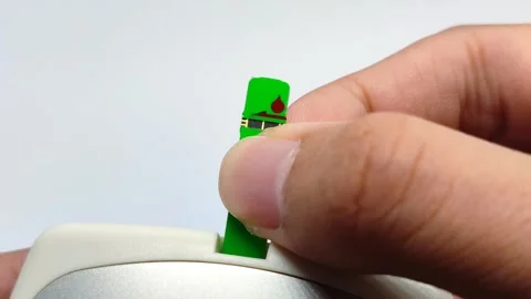 Insert a green blood sugar stick into the device on a white background Stock Footage 294426314