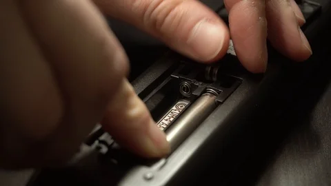 Insert new batteries into remote control. Stockbeeldmateriaal 128663407