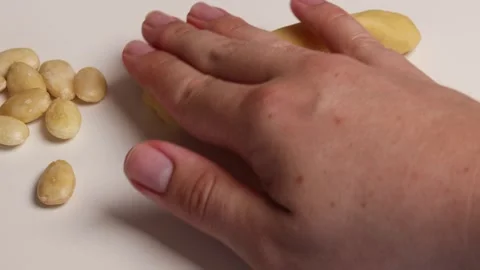 Insert peeled almonds into the raw dough to form witch fingers Stock Footage 285420616