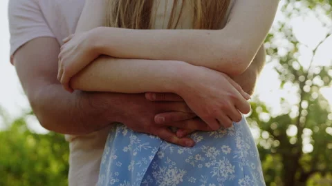 Insert scene of a cropped couple embracing in nature against sunset. Stock Footage 245753056