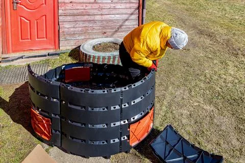 Insert side panels of compost bin into corner posts until fully seated, wom.. Stock Photos