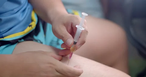 Insert the syringe into the leg and pull the syringe stem to check for blood. Stock Footage 282381850