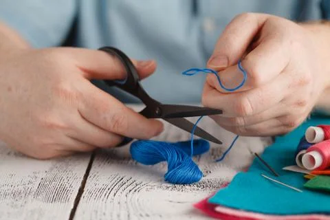 Insert the thread in needle by man hand Stock Photos