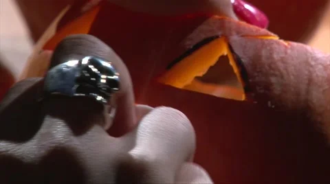 Insert vampire teeth in Halloween pumpkin mouth to make scary lamp, closeup shot Video stock 67897598