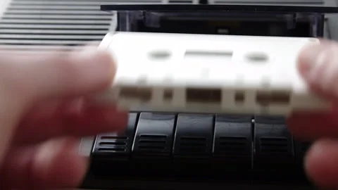 Insert white audio cassette into black cassette player and press play Stock Footage 133522606