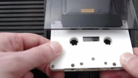 Insert white audio cassette into cassette player and play. Top down shot Video stock 133522632