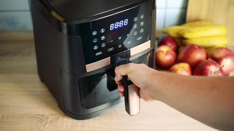 Inserting air fryer basket with raw french fries potato inside machine Stock Footage 342322142