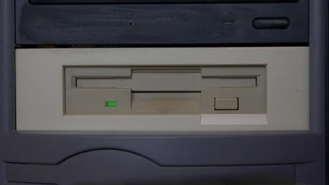 Inserting and ejecting a floppy disk into a vintage computer drive Stock Footage 88156519