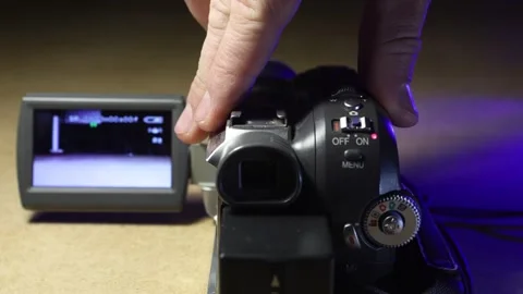 Inserting and removing a mini-cassette into an old mini-dv camcorder Stock Footage 321370107