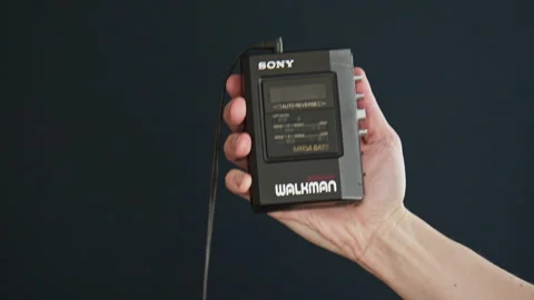 Inserting an audio cassette into a vintage Walkman and pressing play. Stock Footage 306539136
