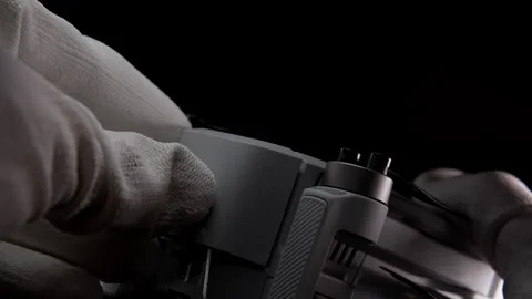 Inserting Battery Into a Drone by Gloved Hands in a Studio Setting Stock Footage 276297646