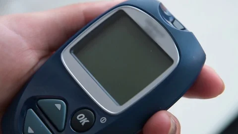 Inserting blood test strip into the glucometer Stock Footage 75146050