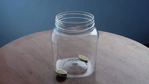 Inserting coins in plastic bottle for saving money Video stock 148901279
