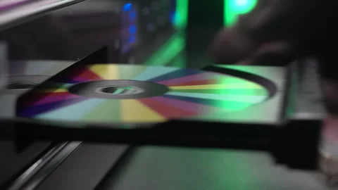 Inserting Colorful Compact Disc in CD Player, Close Up Stockbeeldmateriaal 325785771