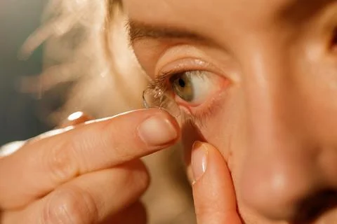 Inserting contact lens into eye for vision correction and daily eye care ro.. Stock Photos