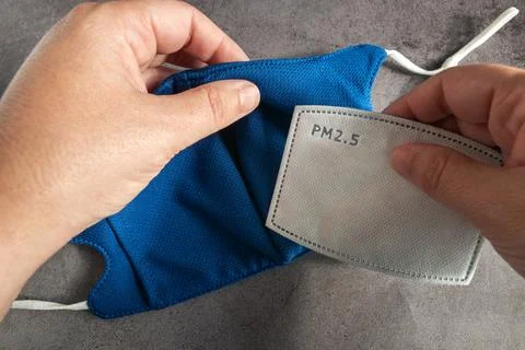 Inserting disposable carbon filter inside the mask Stock Photos