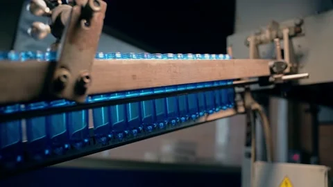 Inserting empty plastic bottle preforms into a conveyor belt 库存影片 149670288
