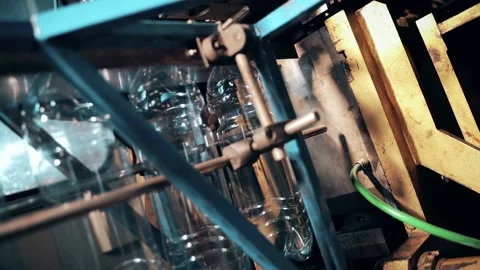 Inserting empty plastic bottle preforms into a conveyor belt 库存影片 149673320