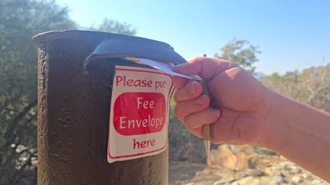 Inserting Envelope into Outdoor Fee Collection Box Stock Footage 321885388