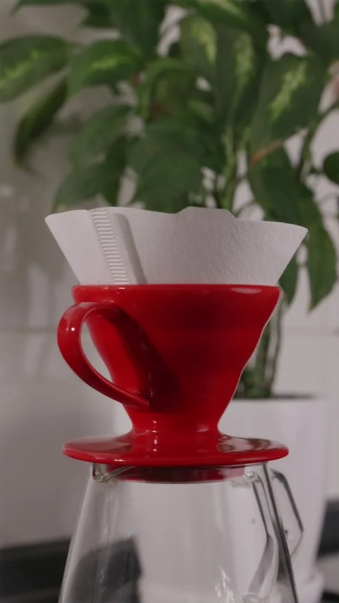 Inserting filter into red V60 dripper with vibrant color accent Stock Footage 332720154