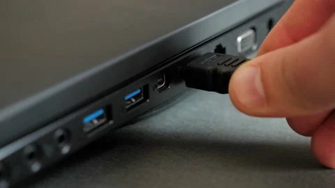 Inserting HDMI cable into the side port of a laptop computer. Stock Footage 130562987