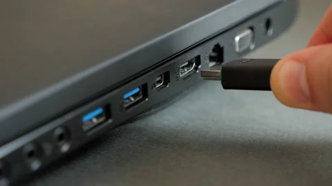 Inserting HDMI cable into the side port of a laptop computer. Stock Footage 130971529