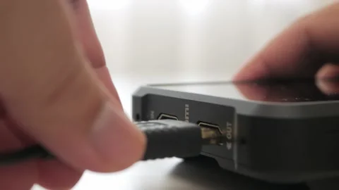 Inserting HDMI cable into the side port of external monitor closeup. HDMI Stock Footage 157670505