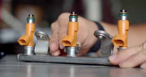 Inserting the injector retaining clips to secure fuel injectors tightly. Stock Footage 314768358
