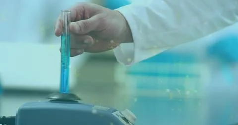 Inserting lab-coated hand holding glass test tube into benchtop mixer, with Stock Photos