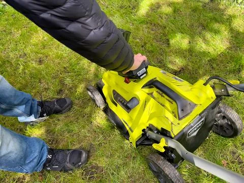 Inserting a Lithium Ion battery on a electric cordless lawnmower Stock Photos