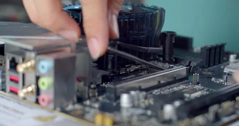 Inserting an M.2 SSD into the motherboard before attaching the heatsink. Stock Footage 311939332