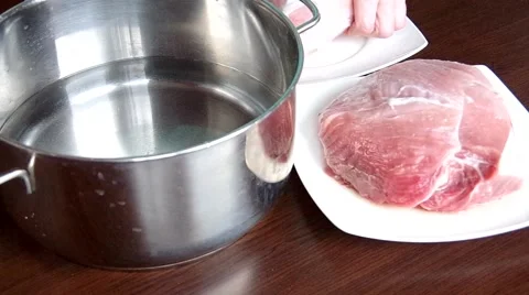 Inserting the meat to the pot Stock Footage 48732485