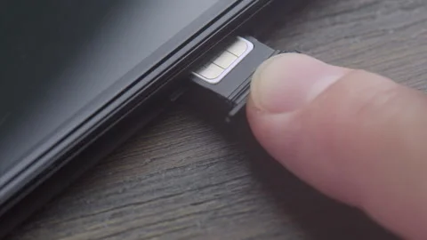 Inserting a modern nano SIM card into a smartphone Stock Footage 320332737