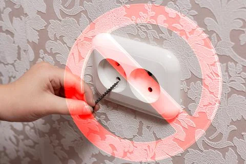 Inserting a nail into an electrical outlet is dangerous, it is life-threateni Stock Photos