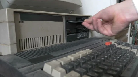 The inserting an old-style 5.25" floppy disk in PC Stock Footage 91373969