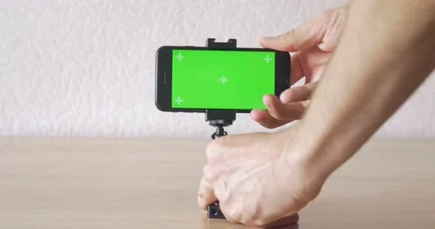 Inserting phone in metal holder on table - green screen Stock Footage 131431497