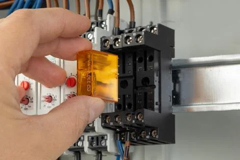 Inserting relay into electrical control panel Stock Photos